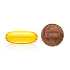 Size comparison of The Gold Standard Omega-3 lemon-infused softgel next to a penny to show easy-to-swallow pharmaceutical grade fish oil.